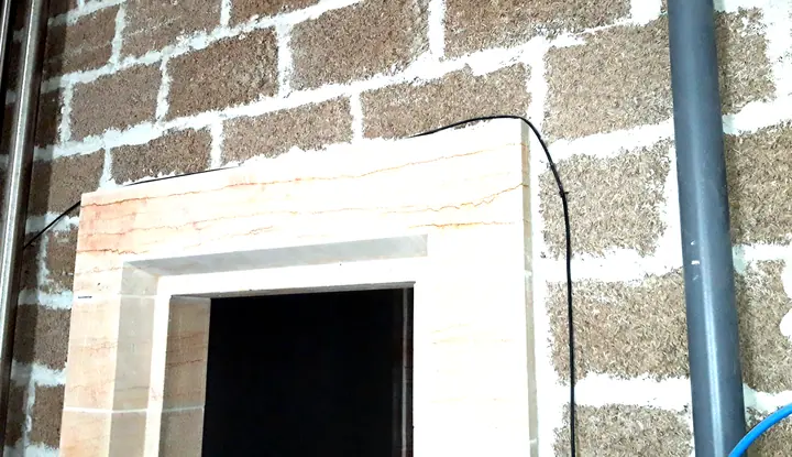 Encadrement de porte en pierre intégré à un mur en blocs MULTICHANVRE