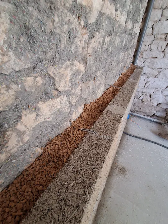 Lit de départ drainant au pied d’un mur en pierre avant doublage en chanvre