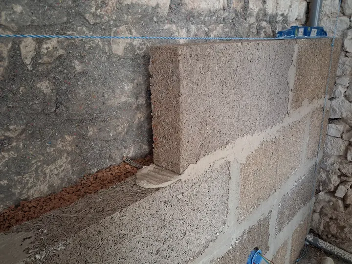 Pose d’un bloc MULTICHANVRE contre un mur en pierre